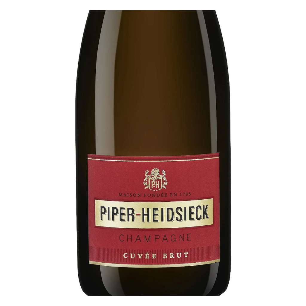 Close do rótulo vermelho clássico do Champagne Piper-Heidsieck, com detalhes da embalagem Le Parfum ao fundo.