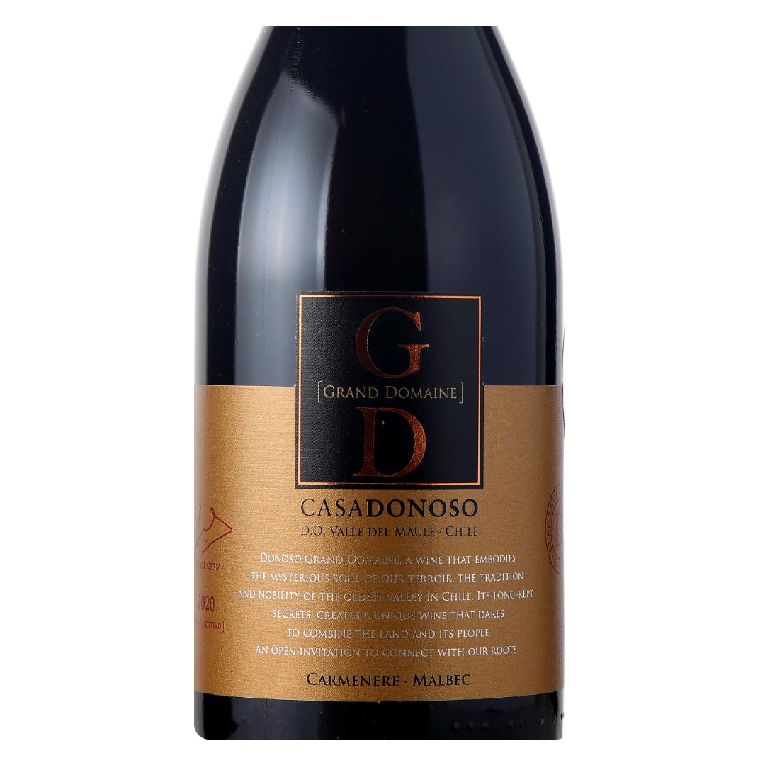 Close-up do rótulo do Grand Domaine, mostrando a linha ícone da Casa Donoso, a uva Carménère e Malbec, a origem Valle del Maule, Chile, safra 2020 e o volume de 750ml.